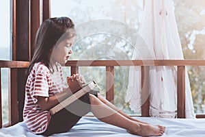 Cute asian little child girl praying with folded her hand