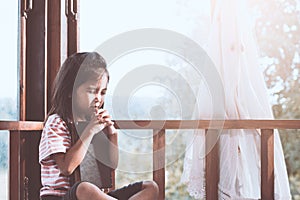 Cute asian little child girl praying with folded her hand