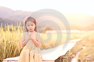 Cute asian little child girl praying with folded her hand