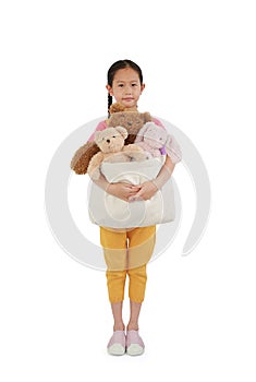 Cute Asian little girl child hugging toys bag for donation. Kid cuddle bag of dolls isolated over white background