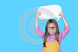 Cute asian little girl holding empty blank speech bubble to say something with smiling and looking straight at camera isolated on