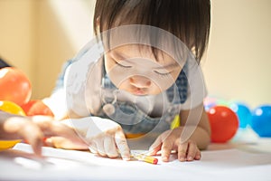 Cute asian little girl is painting the color with fully happiness moment , concept of art and education for kid.toddler girl