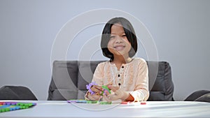 Cute Asian little girl playing with colorful toy ABC jigsaw, Kids play with educational toys at kindergarten or daycare. Creative