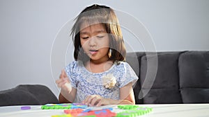 Cute Asian little girl playing with colorful toy ABC jigsaw, Kids play with educational toys at kindergarten or daycare. Creative