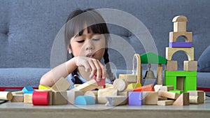 Cute asian little girl playing with colorful toy blocks, Kids play with educational toys at kindergarten or daycare. Creative