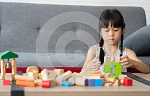 Cute Asian little girl playing with colorful toy blocks, Kids play with educational toys at kindergarten or daycare. The creative