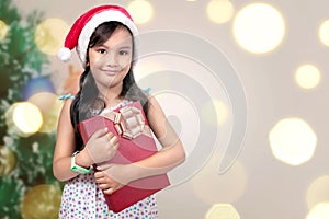 Cute asian little girl with santa hat holding xmas gift box