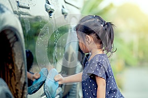Cute asian little girl washing car