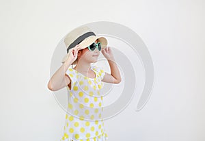 Cute asian little girl wearing sunglasses and straw hat isolated on white background with looking beside. Summer and fashion