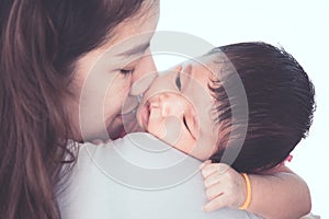 Cute asian newborn baby girl resting on mother`s shoulder.