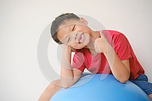 Cute Asian schoolboy child with missing teeth gesturing thumb up sign, Little kid losing his baby teeth