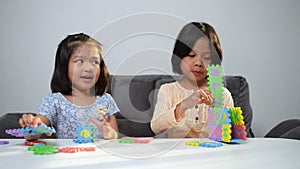 Cute Asian sister same pregnant siblings playing with colorful toy ABC jigsaw, Kids play with educational toys for brain