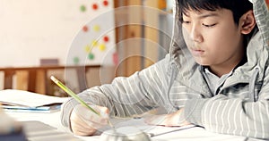 Cute asian teen boy doing your homework at home.
