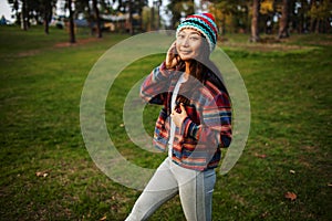 Cute Asian Teen Girl Smilling In Autumn Forest. Candid Woman In Hat Enjoying Autumn In The Forest .