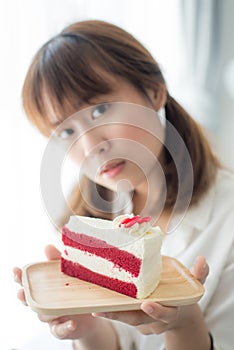 Cute Asian teenager holding strawberry cake