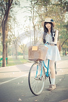 Cute Asian Thai girl in vintage clothing is standing with her bi