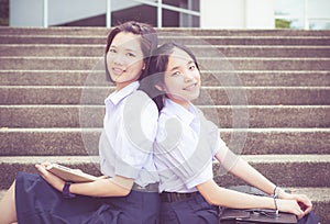 Cute Asian Thai high schoolgirls student couple leaning