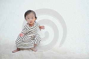 Cute Asian toddler baby girl child playing with sand in sandbox at public playground, Fine motor skills development for little kid