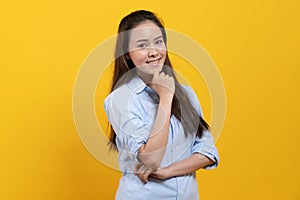 Cute asian woman in casual dress thinking and imagination isolated on yellow background