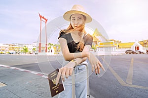A cute Asian woman stands in the middle of Bangkok`s tourist attractions in Thailand