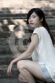 Cute Asian woman in a white top looking at viewer with attitude