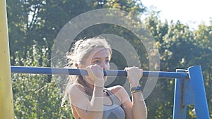 Cute athletic young woman doing pull up