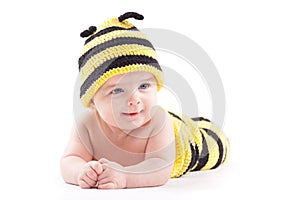 Cute attractive baby boy in bee costume lies on tummy