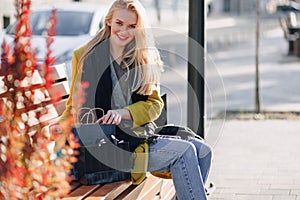 Cute attractive blonde woman with packages on the street in sunny weather. shopping and positive emotions