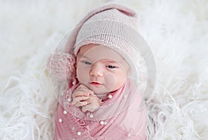 Cute awake newborn in knitted hat