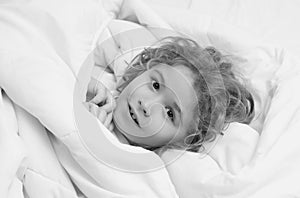 Cute awaking child in bed, bedtime, childhood and growth kids concept, close-up indoor portrait. photo