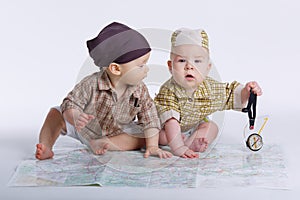 Cute babies planning travel with map