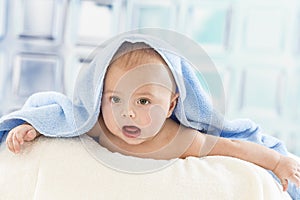 Cute baby with adorable face in bath towel after