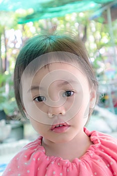Cute baby Asian girl, little toddler child with adorable short bang hair looking at camera