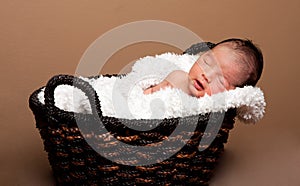 Cute baby asleep in basket photo