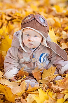 Cute baby in autumn leaves.