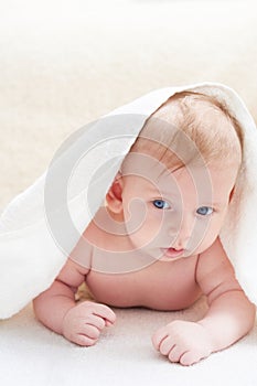 Cute baby after bath in towel on a light background
