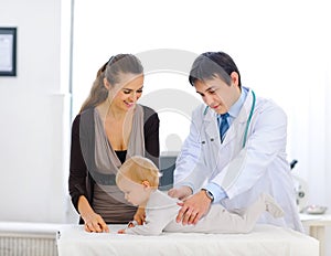 Cute baby being checked by a pediatric doctor