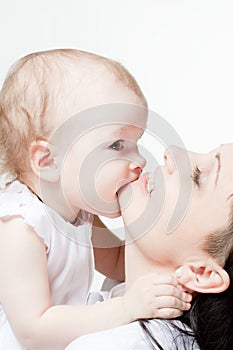 Cute baby biting her mother's chin