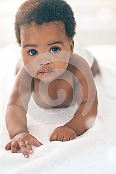 Cute baby, black kids and portrait of crawling on bed for play, fun and relax in nursery room. Young african infant