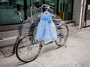 Cute baby blue and white dress hang on bicycle