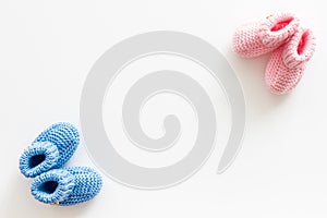 Cute baby booties for girl and boy on white background top view copyspace