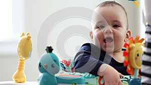 Cute Baby Boy in Baby Bouncer at Home. Infant Playing in Baby Activity Center. Happy, Smiling