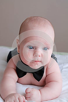 Cute baby boy with blue eyes in a bow tie.