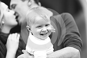 Boy smiles while parents kiss