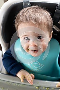 Cute baby boy eating avocado