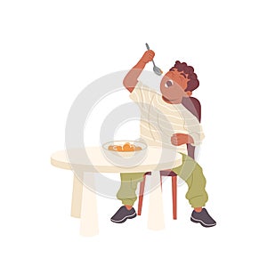 Cute baby boy eating porridge in bowl with spoon sitting at table isolated on white background
