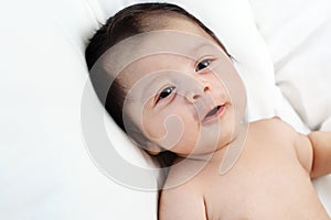 The cute baby boy is happy relax closeup on the white bed