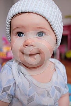 cute baby boy in a hat making funny faces at home