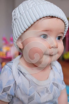 cute baby boy in a hat making funny faces at home