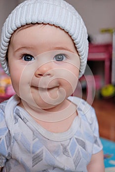 cute baby boy in a hat making funny faces at home